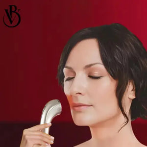"Silver electric pore cleaner held near a woman's face, with a red background and soft lighting."