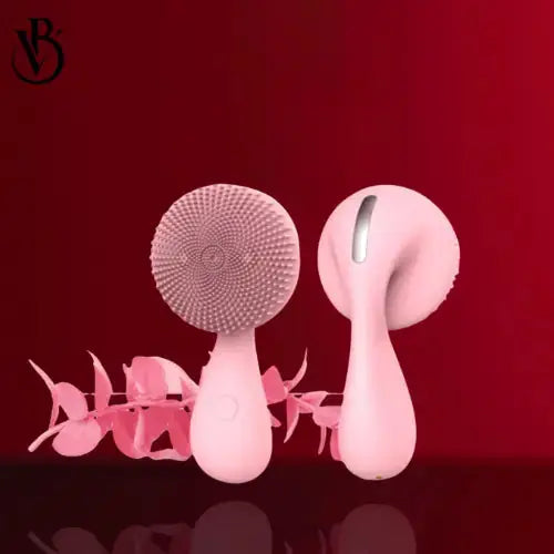 "Pink sonic facial cleansing brush with textured head and smooth handle, displayed against a red background."