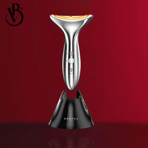 "Silver 4-in-1 neck firming device with an ergonomic handle, placed upright in a black charging base, against a red backgroun