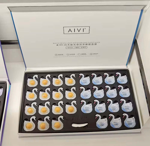 "Open box of AIVI Overnight Hydrating Capsules featuring white swan-shaped masks in a black foam insert."