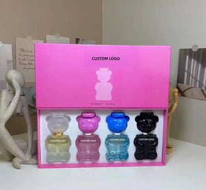 "Pink gift box with five mini bear-shaped perfume bottles in various colors: clear, blue, and black, with custom logos."
