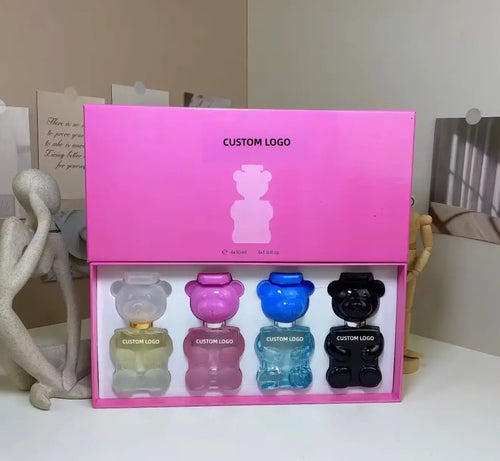 "Pink gift box with five mini bear-shaped perfume bottles in various colors: clear, blue, and black, with custom logos."