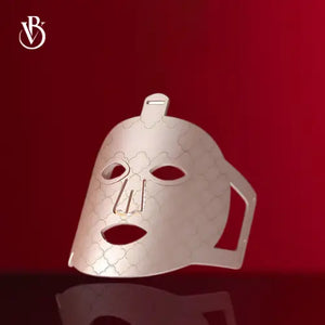 "7-Color LED light therapy mask in white with hexagonal pattern, featuring eye and mouth cutouts, angled view."