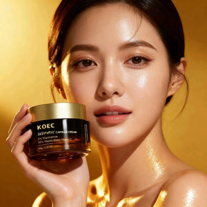 "KOEC Deep Vita C Capsule Cream in a dark brown jar with a gold lid, held by a woman with glowing skin."