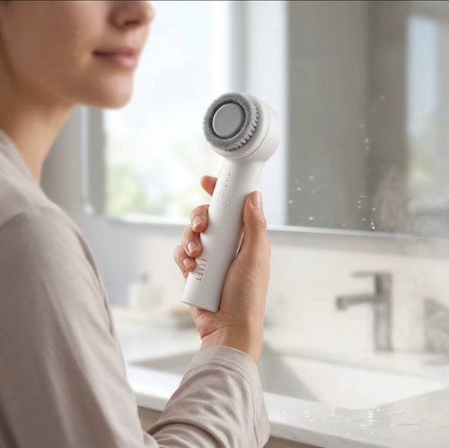 Handheld facial cleansing brush in use