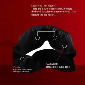 "Black fabric eye mask with adjustable elastic band, featuring two built-in lodestones, side view on red background."